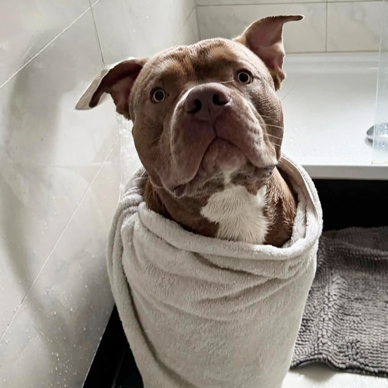 Biggi sitzt mit Handtuch umgelegt im Bad nach dem Duschen